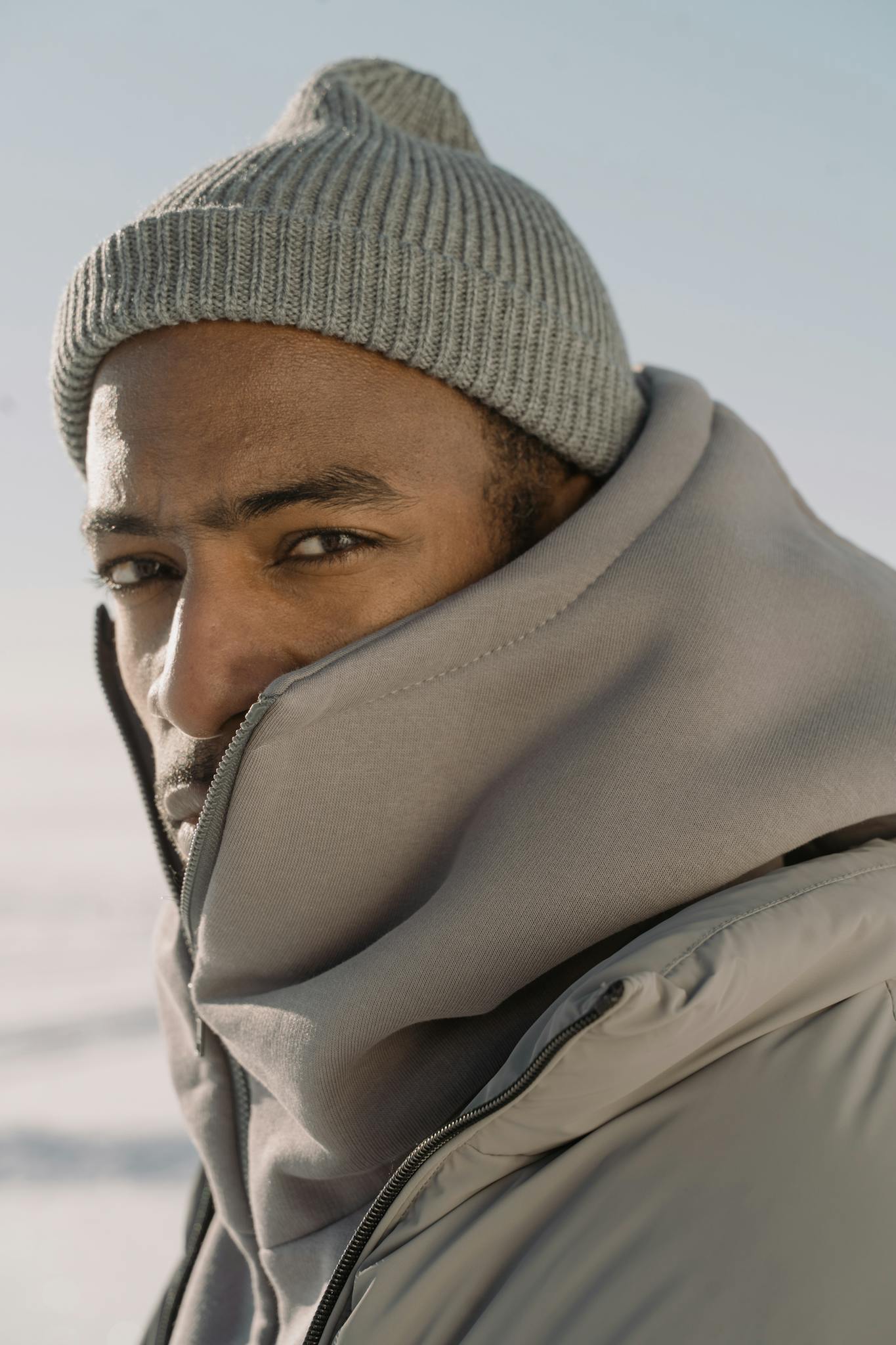 Close-up of a man in winter attire with knit hat and puffer jacket.