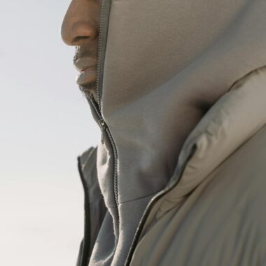 Close-up profile of a man in a hoodie and puffer jacket. Fashionable winter style.